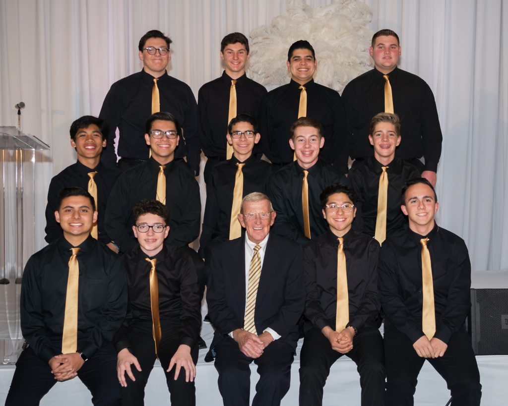 Hall-of-Fame Notre Dame coach Lou Holtz poses with Servite's Select Choir during Servite's Excellence in Leadership Dinner.
